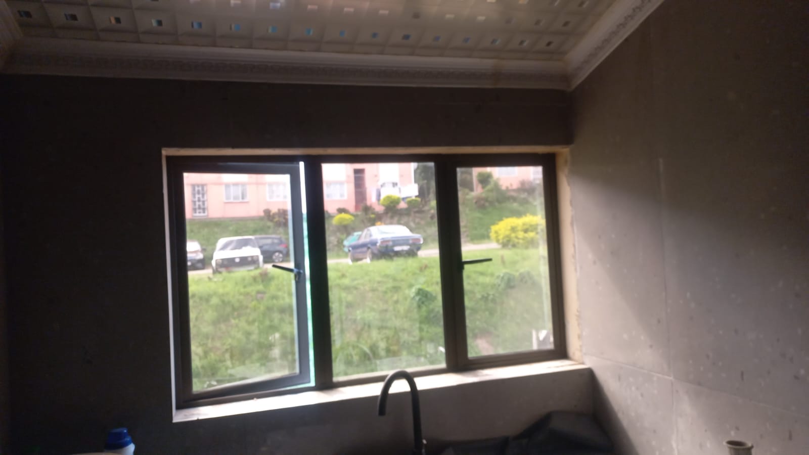 Interior aluminium window opening onto a garden view