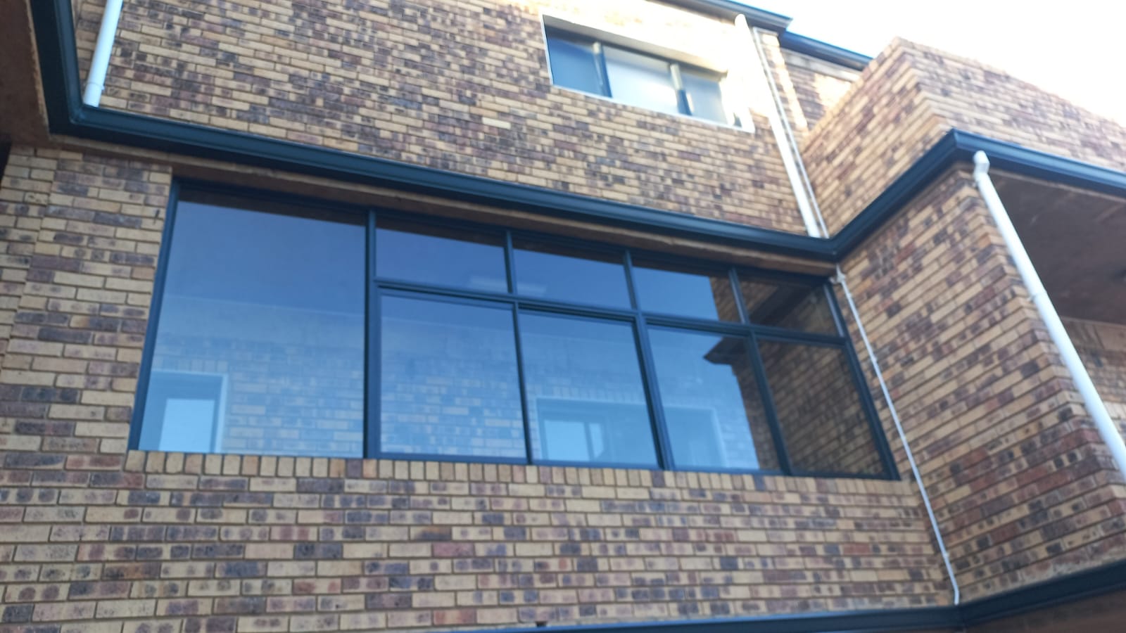 Blue aluminium windows fitted to a brick building