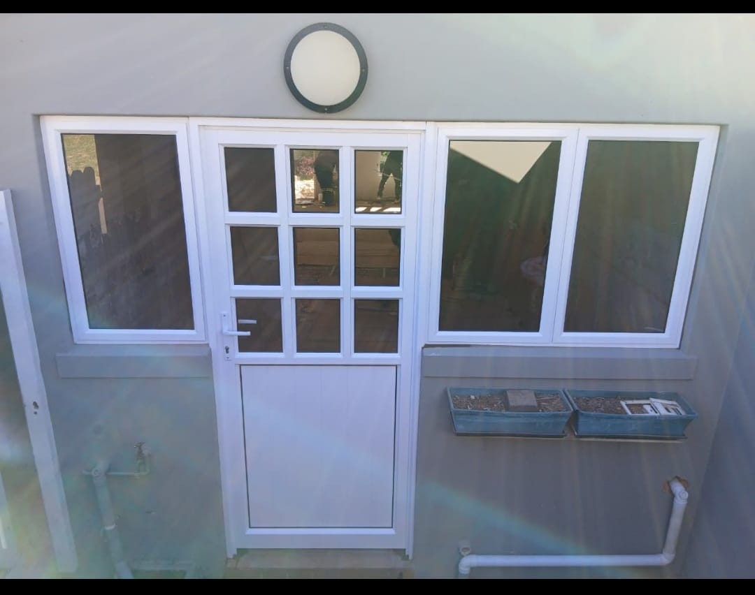 White aluminium door with matching side windows on a grey wall