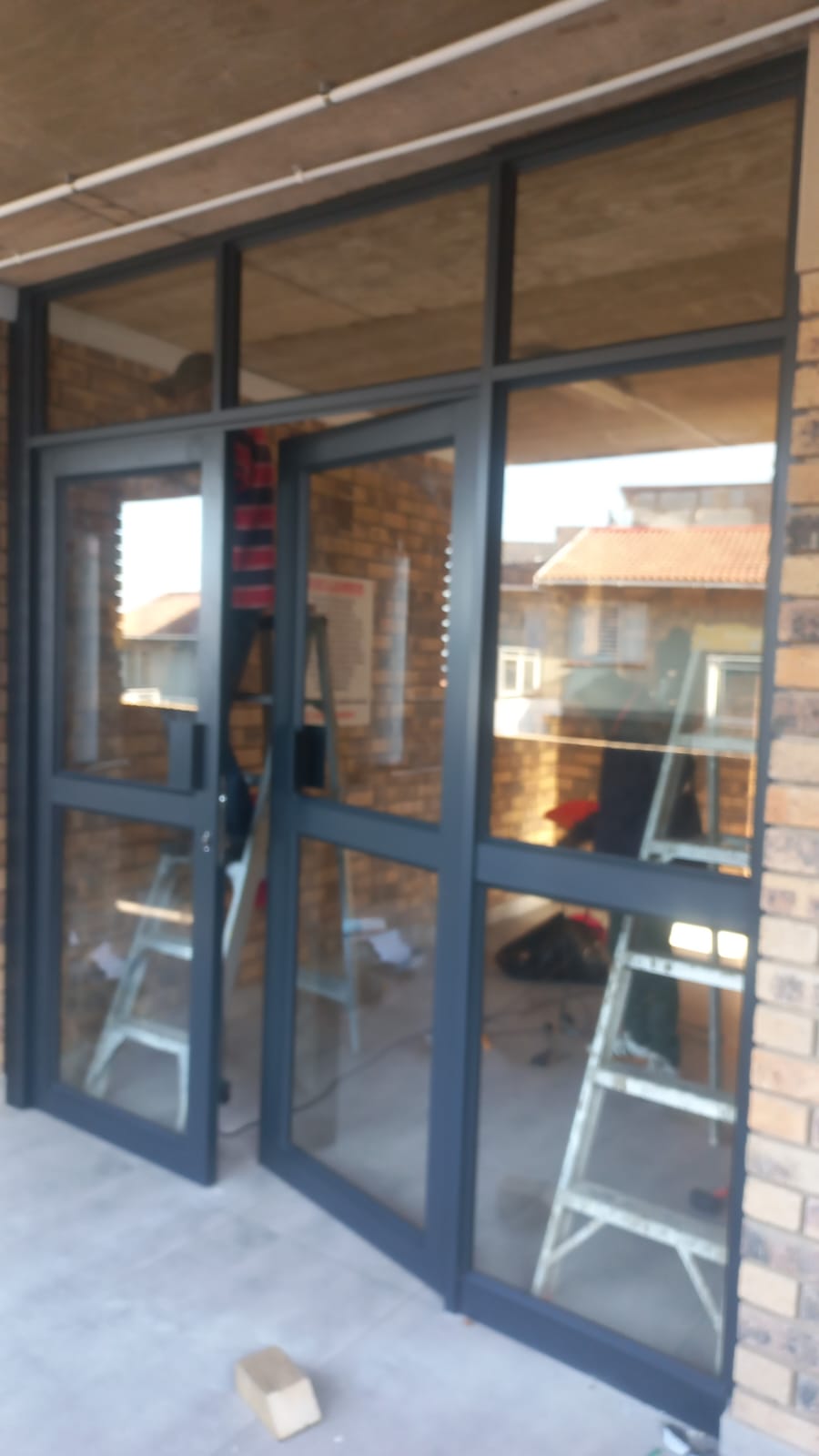 Dark grey aluminium glass doors installed under a patio