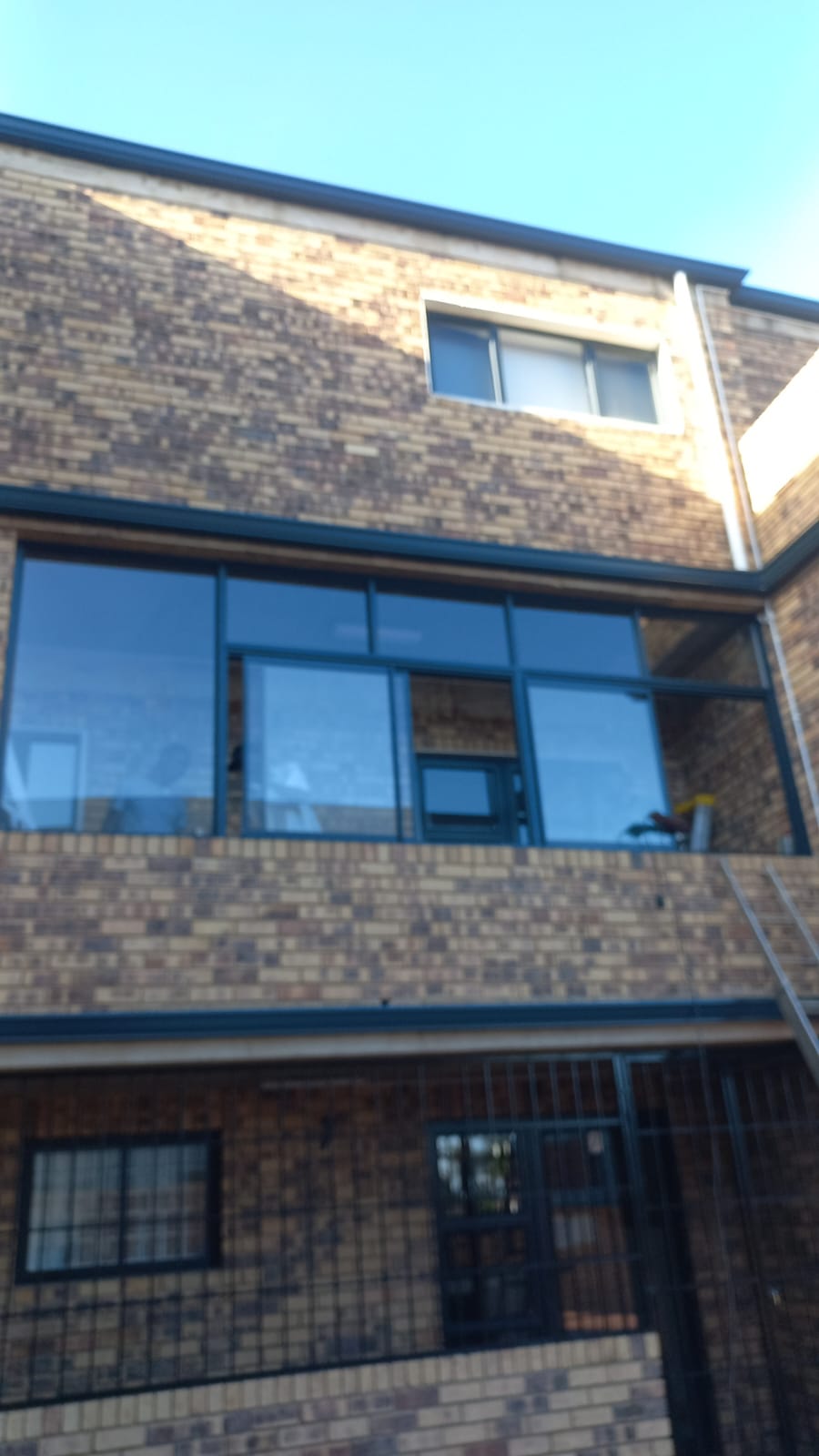 Upper floor aluminium windows on a brick building
