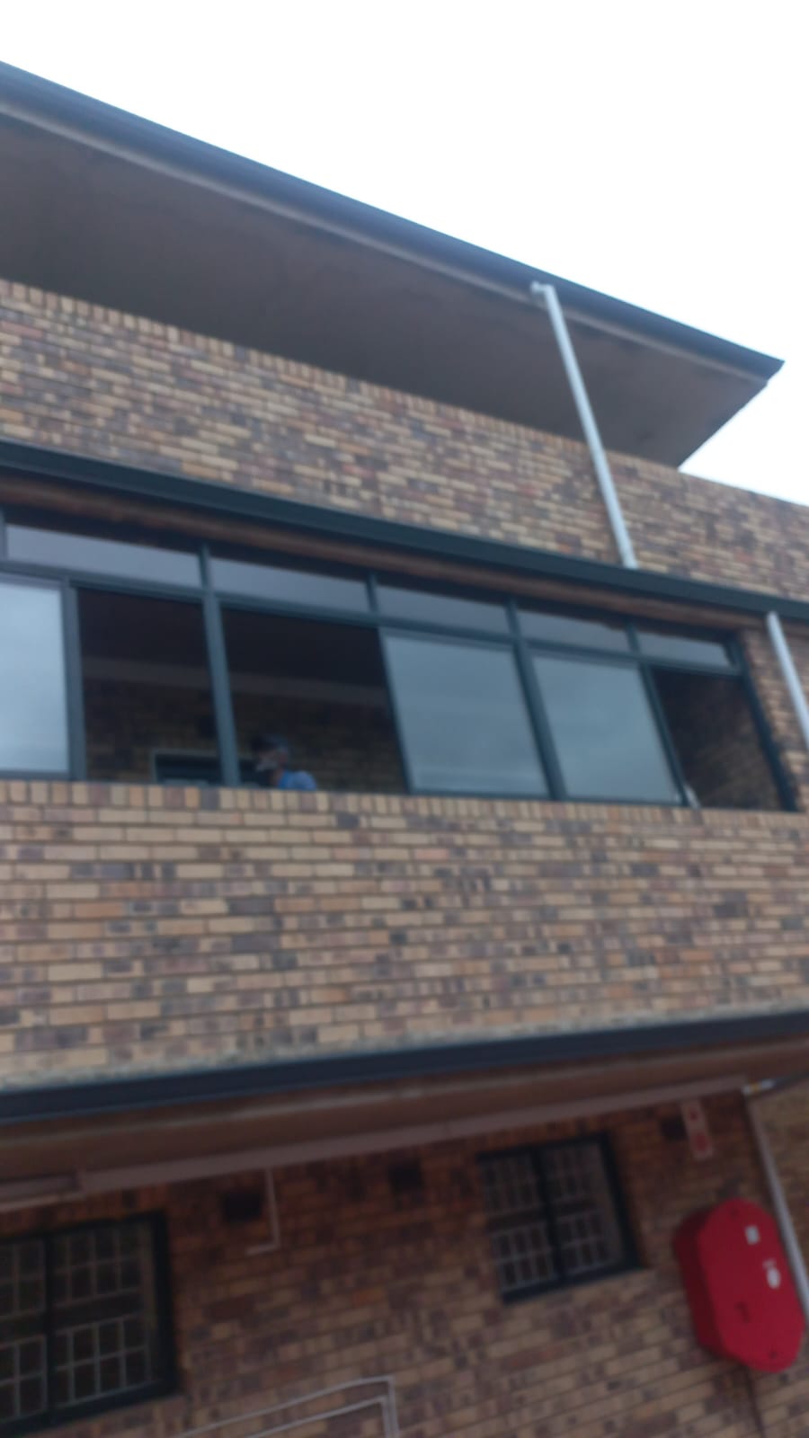 Upper floor aluminium windows on a brick building