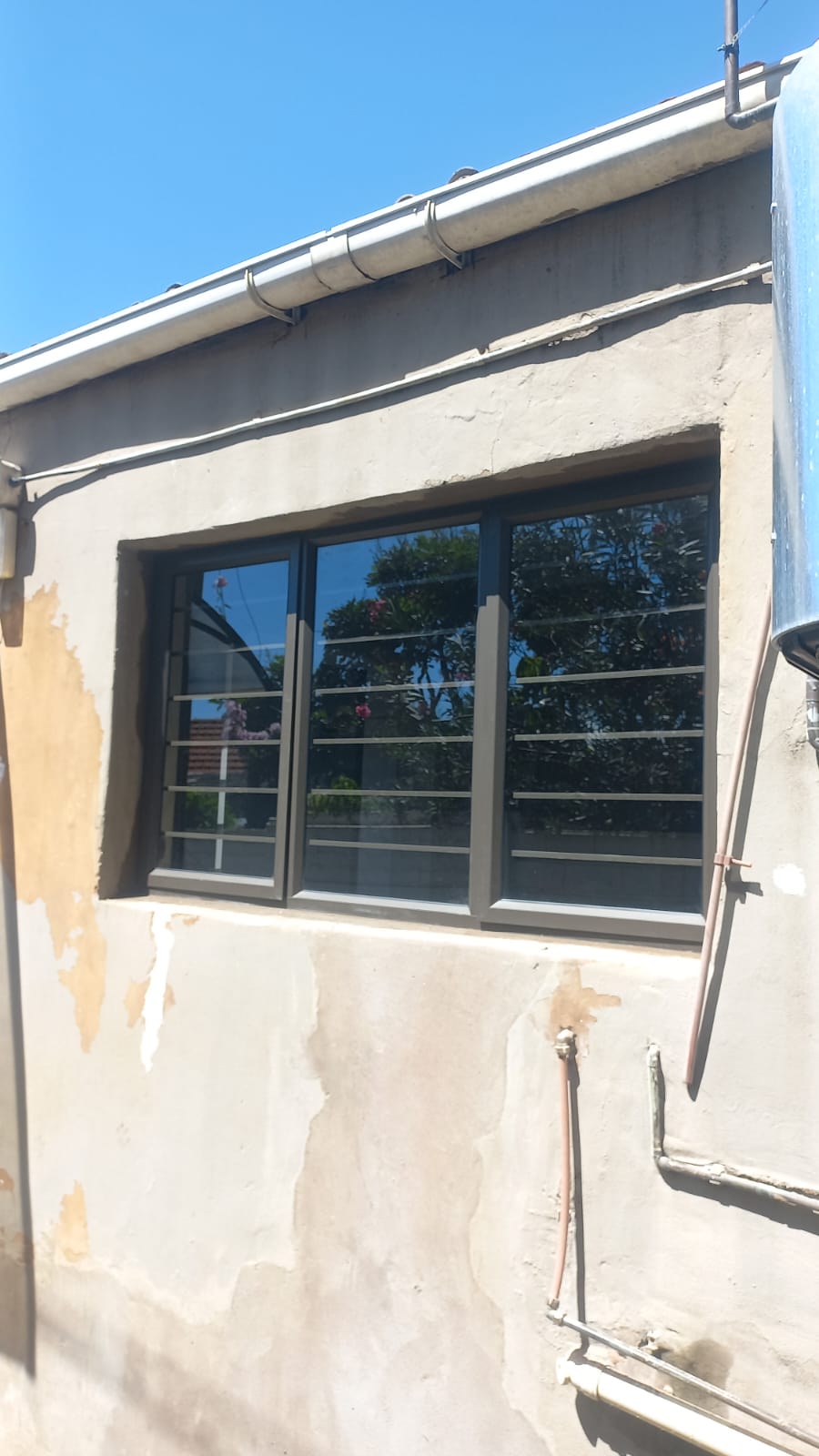 Dark-framed aluminium windows with horizontal security bars