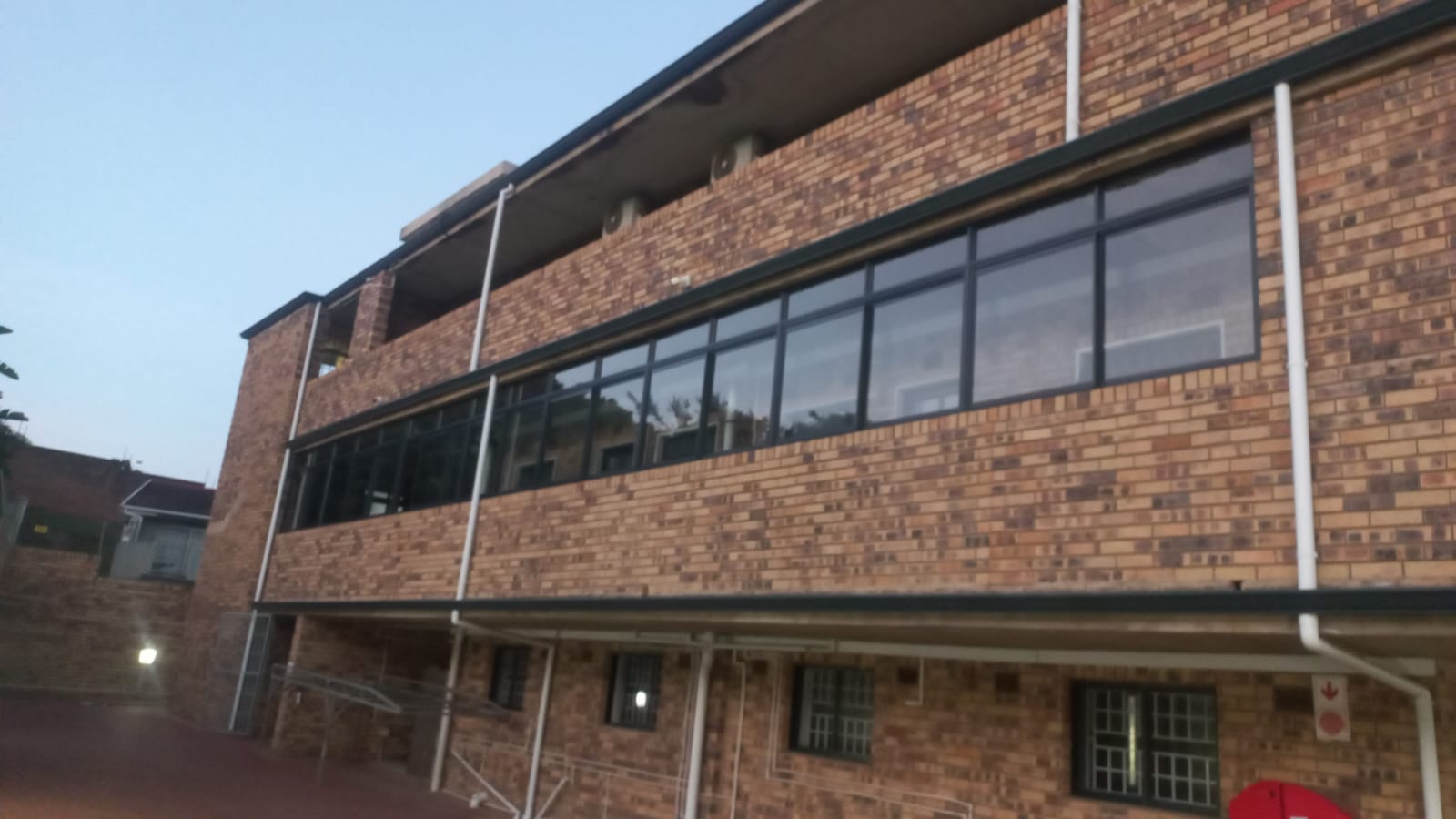 Upper floor aluminium windows on a brick building exterior